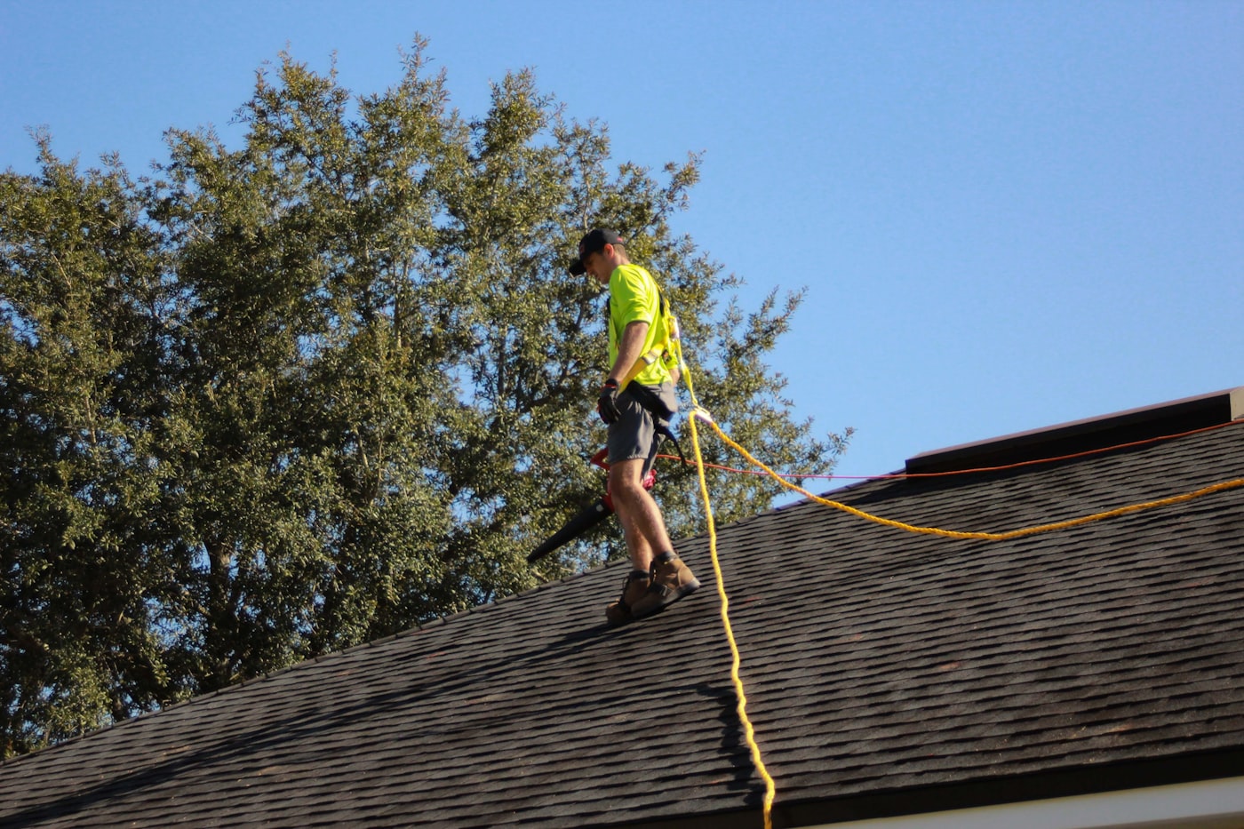 Professional roofer repairing architectural shingles on residential home